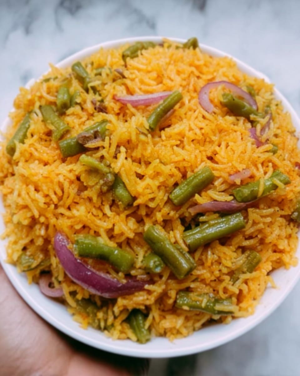 A white bowl filled with yellow-orange rice mixed with small pieces of green beans and purple onions. The rice looks soft and fluffy, with some small spices visible throughout. The pieces of vegetables are spread evenly inside the rice. A woman's hand is holding the bowl on a white marbled surface. photo taken with an iphone --ar 4:5 --v 7
