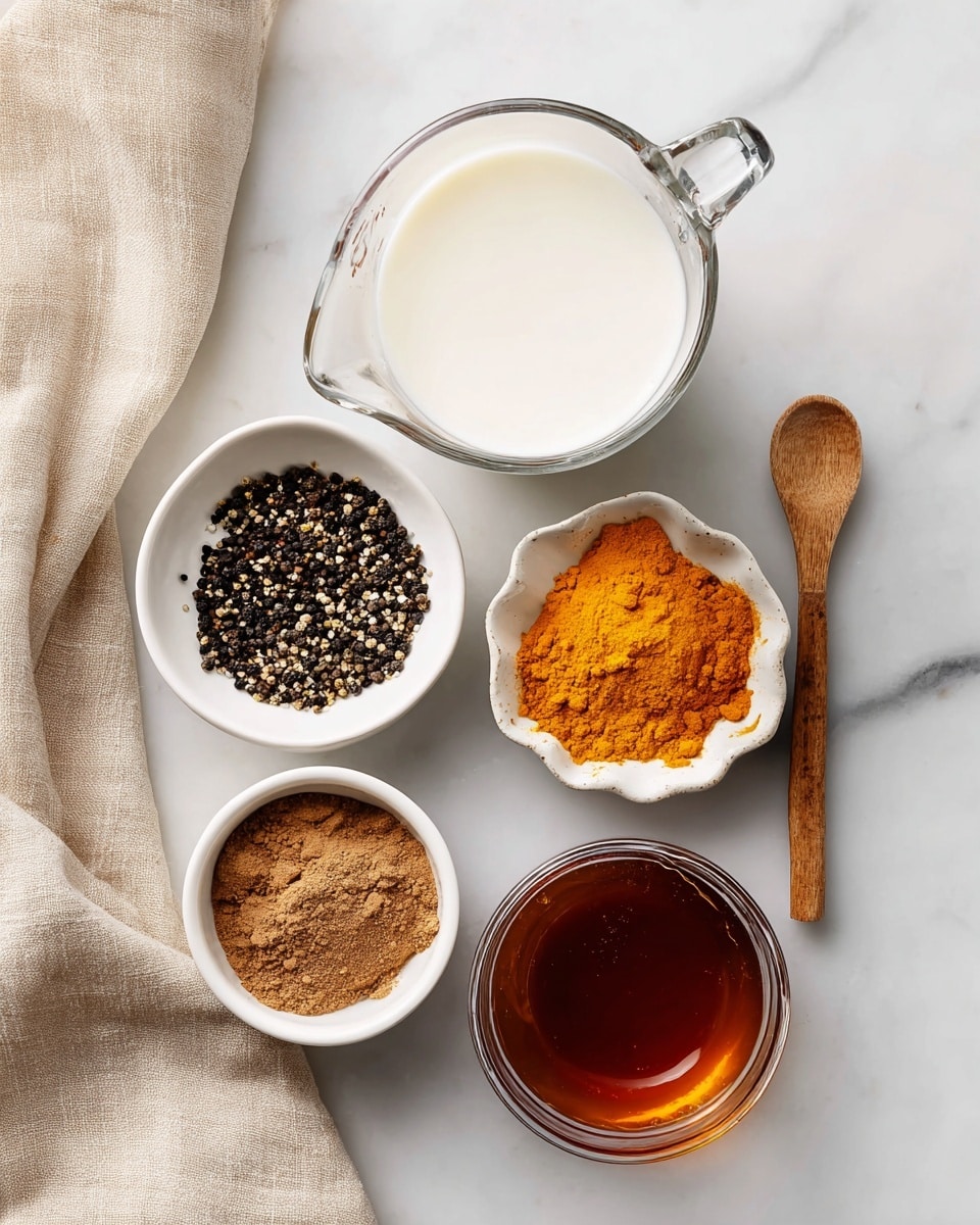 The image shows five ingredients placed on a white marbled surface with a beige cloth to the left. At the top is a clear glass measuring cup filled with white milk. Below it, to the left, is a small white bowl filled with black pepper, which has a coarse texture and black and brown specks. To the right of the pepper is a white bowl with bright orange turmeric powder and a small light brown wooden spoon resting in it. Below the turmeric bowl is a small white ramekin containing fine brown cinnamon powder with slight texture lines. Finally, at the bottom center is a clear glass cup filled with dark amber maple syrup, showing smooth liquid texture. Photo taken with an iphone --ar 4:5 --v 7