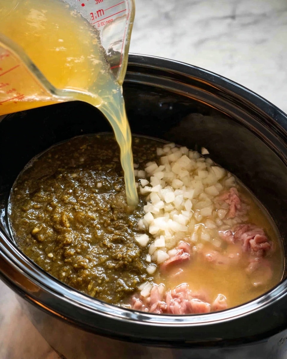 In a black slow cooker, there are several layers of ingredients. On the left side, there is a thick, dark green chunky sauce. Next to it, in the upper center, is a layer of small, white chopped onions. On the right side, there is a light tan liquid with small pink pieces of raw meat partially covered by the liquid. A clear measuring cup is pouring more light yellow broth into the slow cooker from the top left corner. The slow cooker is on a white marbled countertop. The overall scene shows the early stage of cooking a stew-like dish. photo taken with an iphone --ar 4:5 --v 7