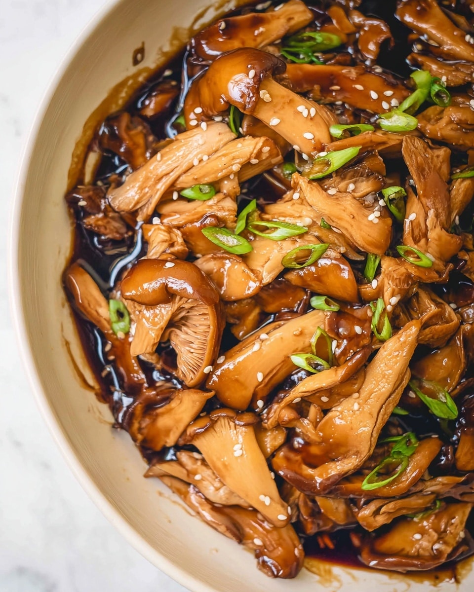 A close-up of a white bowl filled with cooked oyster mushrooms soaked in a dark, glossy sauce. The mushrooms vary in shape and size, with some sliced and some whole, their light brown color contrasting with the deep brown sauce. Small green chili slices and sesame seeds are scattered on top, adding a touch of green and white texture. The bowl is placed on a white marbled surface with a bit of sauce spilled around the edge. Photo taken with an iphone --ar 4:5 --v 7