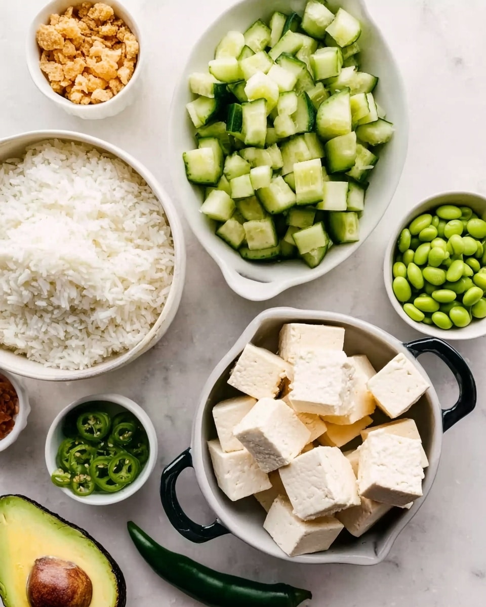 The image shows a white bowl of cooked white rice on a white marbled surface. Below it, a white oval bowl holds chopped green cucumber pieces with smooth skin and light green inside. To the right, a white bowl with two black handles contains bright green edamame beans. Below the cucumber bowl, there are small white cubes of tofu arranged in a pile. Next to it is one avocado half with a rough dark green outside and a light green inside. At the bottom left, a small white bowl contains a crunchy light brown snack. A green chili pepper lies near the tofu cubes. Various small containers hold different ingredients in the corners. photo taken with an iphone --ar 4:5 --v 7