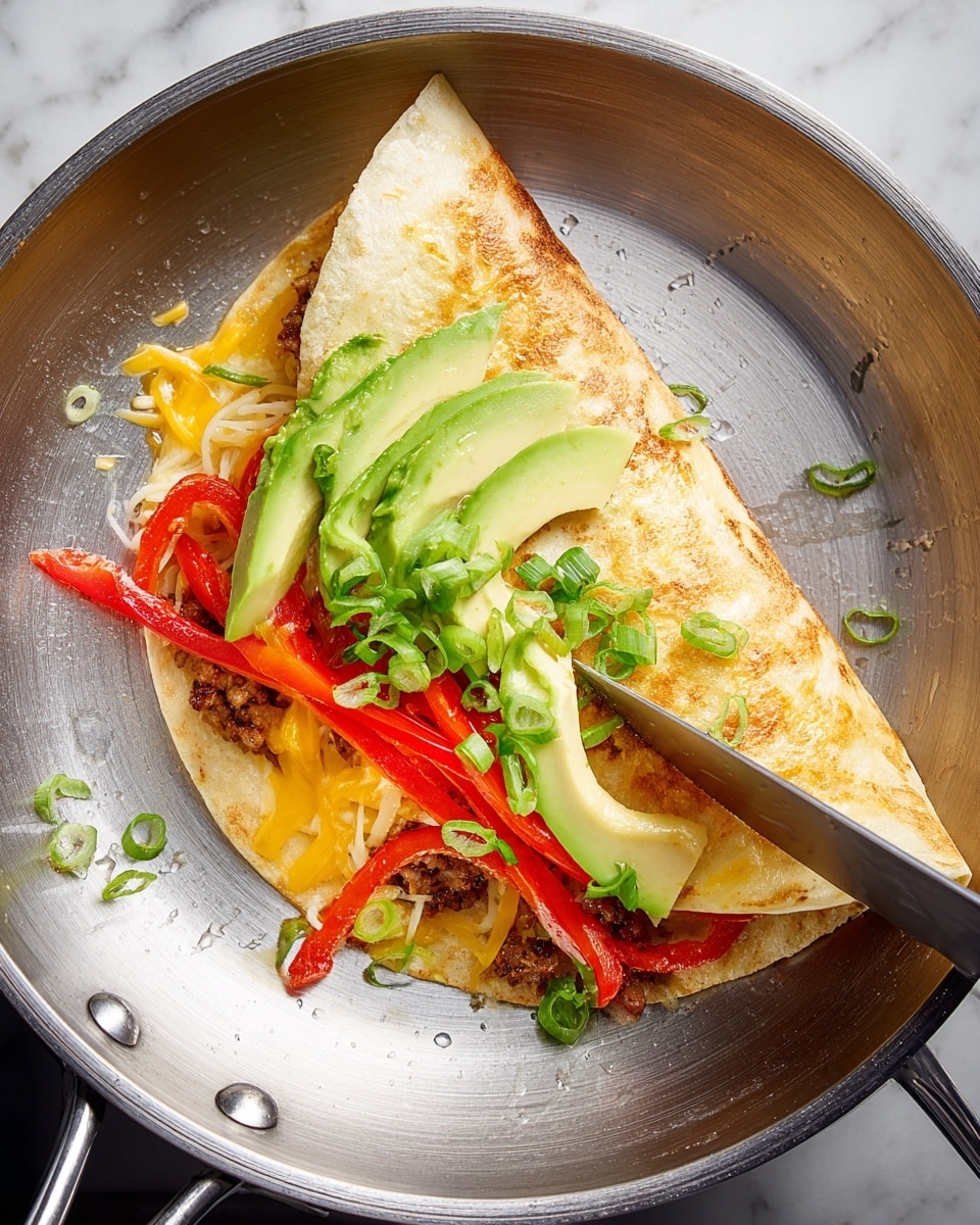 A soft tortilla is folded over in a shiny silver pan, showing its fillings inside. The bottom layer is melted yellow cheese oozing slightly on the tortilla, with cooked strips of red bell pepper sitting on top. There are slices of cooked seasoned meat underneath several bright green slices of fresh avocado. On top, finely chopped green onions are sprinkled, adding a fresh touch. A knife is gently holding the tortilla open from the right side. The pan sits on a surface with a white marbled texture photo taken with an iphone --ar 4:5 --v 7