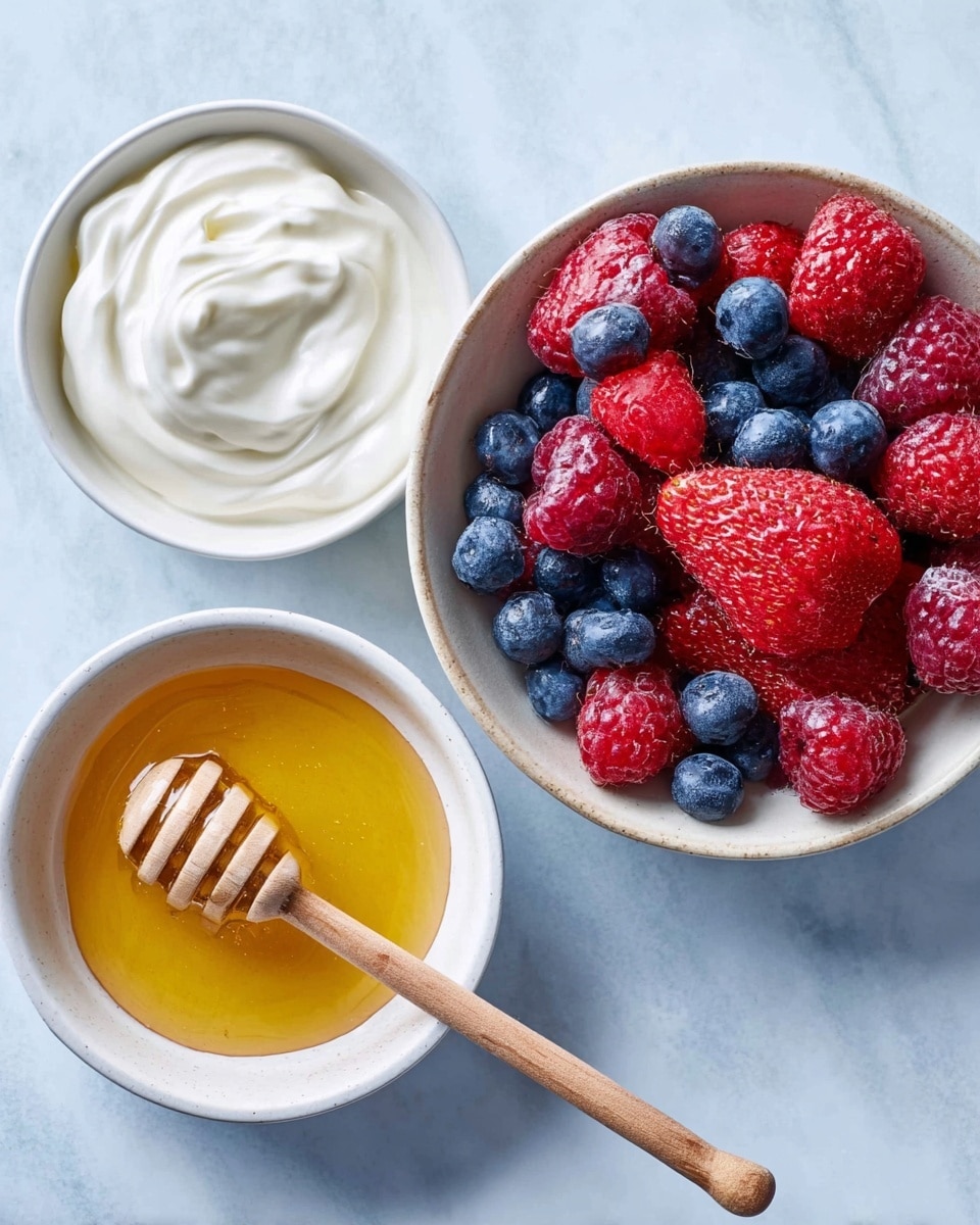 The image shows three white bowls on a white marbled surface. The first bowl, placed at the top left, is filled with smooth white yogurt with soft swirls on top. The second bowl, positioned at the bottom center, contains golden honey with a wooden honey dipper resting on it. The third bowl, located at the right, is filled with frozen mixed berries, including red strawberries, red raspberries, and blue blueberries. Photo taken with an iphone --ar 4:5 --v 7