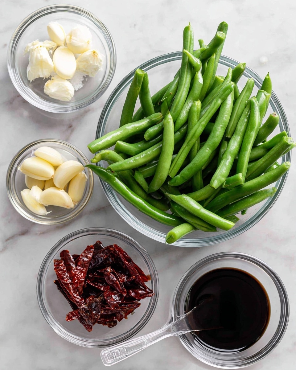 A clear glass bowl filled with fresh green beans takes the center, the beans bright and smooth with light green color. Around it are smaller clear glass bowls with white salt crystals, peeled garlic cloves that are creamy yellow, and whole red dried chillies that are dark red and wrinkled. Below on the white marbled surface, a clear measuring spoon holds black oil, shiny and thick. The bowls and ingredients sit neatly spaced on the white marbled texture background. photo taken with an iphone --ar 4:5 --v 7