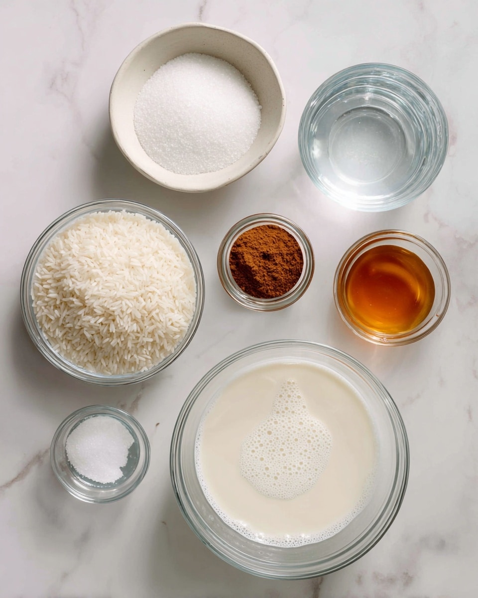 The image shows seven clear glass bowls and one white bowl arranged on a white marbled surface. The largest glass bowl in the lower right is filled with white milk with a slightly frothy surface. To its left, a small white bowl contains a pinch of salt. Above the salt bowl is a medium-sized glass bowl filled with white granulated sugar. Next to the sugar is a small glass jar with brown cinnamon powder inside. In the center is a clear glass bowl filled with white, uncooked rice grains. To the right of the rice bowl, a transparent plastic cup holds clear water. Finally, there is a small glass bowl with a light amber vanilla liquid. The bowls are evenly spaced and labeled with black text positioned above or near each item. photo taken with an iphone --ar 4:5 --v 7