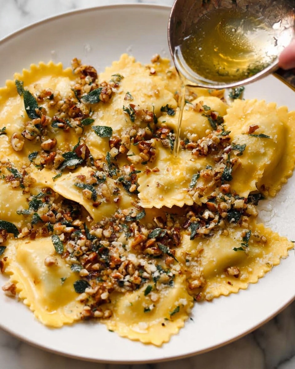 A white plate filled with a single layer of yellow ravioli pasta showing a soft, smooth texture. On top, there is a layer of small chopped nuts and green herbs scattered unevenly, creating a mix of brown and dark green colors with a slight shine from melted butter being poured from a metal pan into the top right, where a woman's hand holds the pan. The white marbled surface underneath adds a clean, bright background to the dish. Photo taken with an iphone --ar 4:5 --v 7