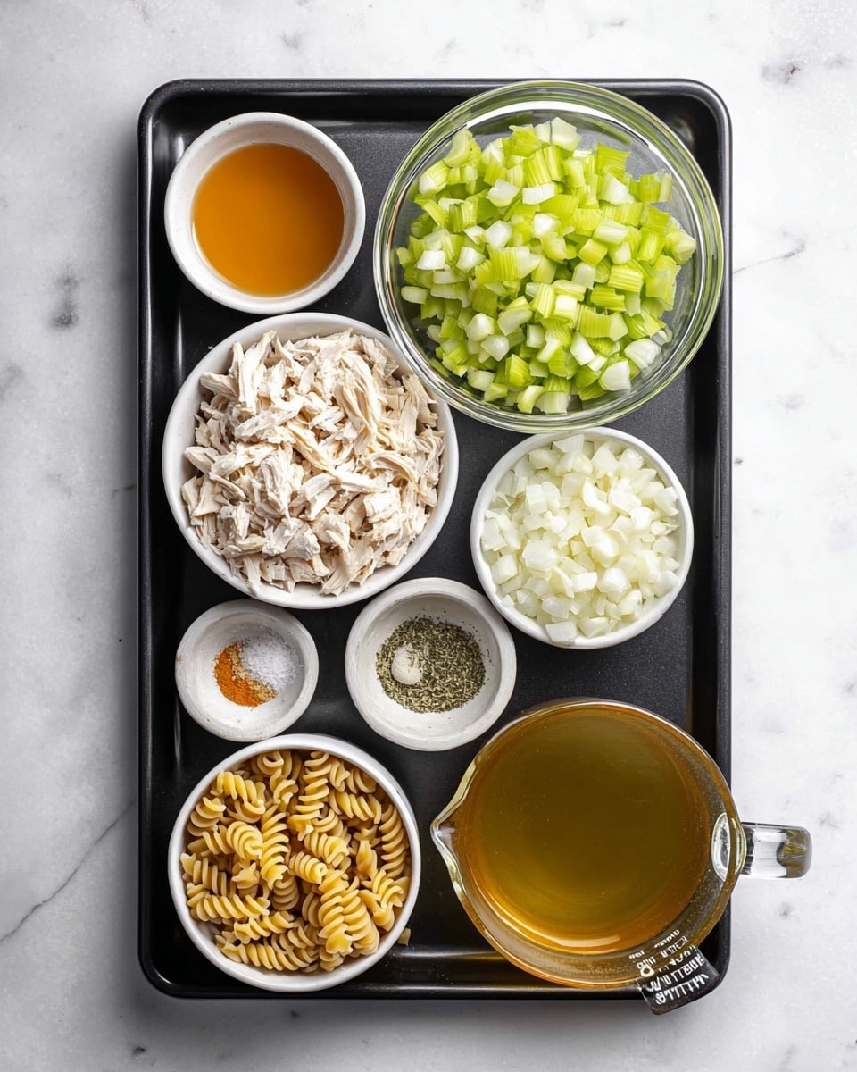 A rectangular black baking tray holds several clear and white bowls with different chopped ingredients on a white marbled surface. At the top center is a clear glass bowl with light green chopped celery. To the right is a similar bowl with white chopped onions. Below the celery bowl is a small white bowl filled with minced garlic. Below the garlic and onions is a white bowl filled with dry fusilli pasta showing a light yellow color and spiral shapes. To the bottom left is a white bowl filled with shredded white chicken. Next to the chicken is a small white bowl with dried herbs and salt. Above it is a clear small bowl with a golden liquid, likely oil, and next to this is another small clear bowl with a dark yellow liquid. At the bottom right corner is a clear glass measuring cup filled with light golden broth. Photo taken with an iphone --ar 4:5 --v 7