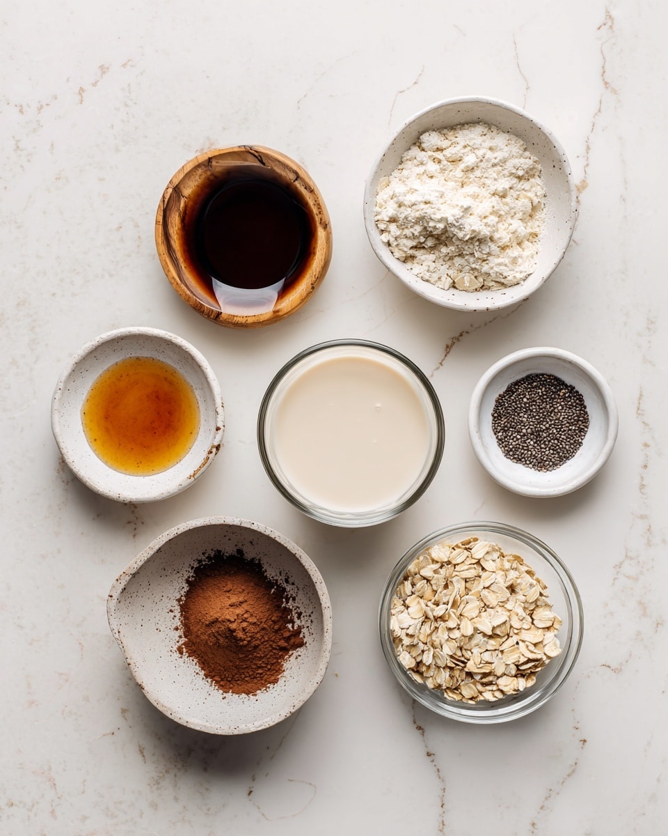 A top view of seven small white dishes and bowls placed on a white marbled surface. In the center is a small glass bowl filled with creamy off-white almond milk, surrounded clockwise by a small white bowl of dark maple syrup, a small white bowl with amber vanilla extract, a small white bowl with light brown cocoa powder, a small wooden bowl with white salt, a small white bowl with dark chia seeds, and a small clear bowl with pale beige rolled oats. Each dish is neatly labeled with black text on a white background. photo taken with an iphone --ar 4:5 --v 7