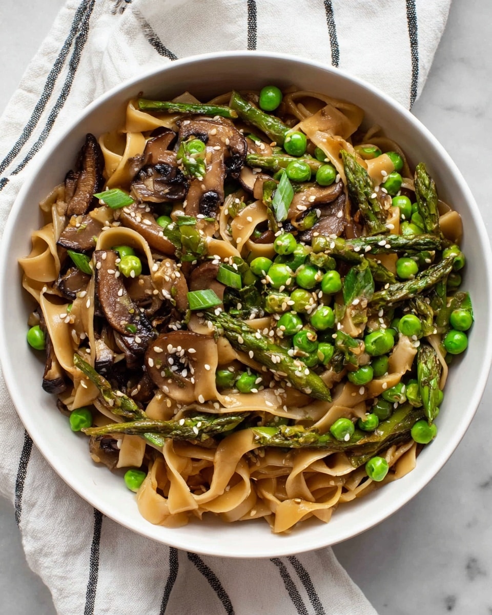 A white bowl filled with three main layers: at the bottom are broad, flat light brown noodles, on top are bright green peas and asparagus pieces scattered evenly, and the top layer consists of dark brown cooked mushroom slices mixed with chopped green onions. White sesame seeds are sprinkled over the whole dish, adding small white dots in contrast. The bowl sits on a white marbled surface with a white cloth that has thin black stripes beside it. photo taken with an iphone --ar 4:5 --v 7