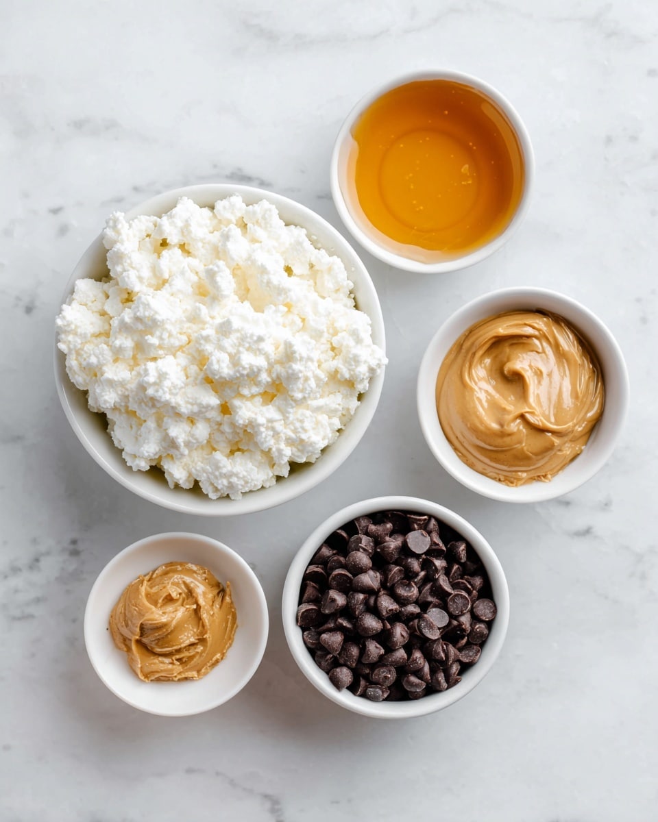 The image shows four small white bowls on a white marbled surface. The largest bowl in the center is filled with white, lumpy cottage cheese with a soft texture. Above it, a smaller bowl contains thick golden honey with a smooth surface. To the right, a white bowl is filled with shiny dark brown chocolate chips, smooth and small. Below the cottage cheese, another white bowl holds creamy peanut butter, which is light brown and smooth with some texture. The scene is bright and clean, with clear labels for each ingredient. photo taken with an iphone --ar 4:5 --v 7