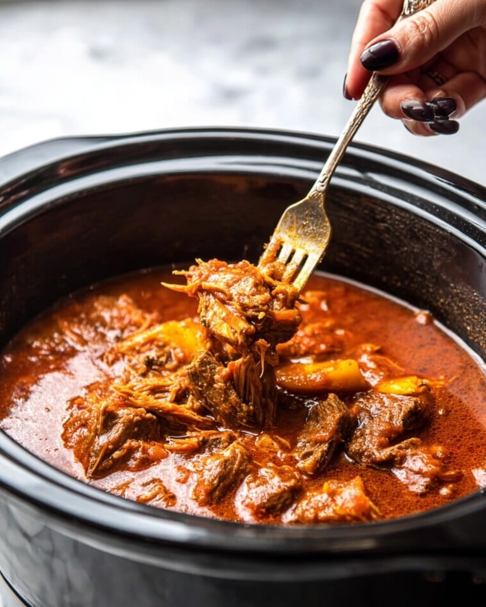 The image shows a black slow cooker filled with rich red-orange stew that has shredded pieces of tender meat in it. The stew looks thick and has chunks of meat softly breaking apart. A woman's hand with dark-colored nails is holding a fork that is pulling a piece of meat from the stew, lifting it up with a glistening, saucy texture. The background features a white marbled surface, making the dark slow cooker and vibrant stew stand out. photo taken with an iphone --ar 4:5 --v 7