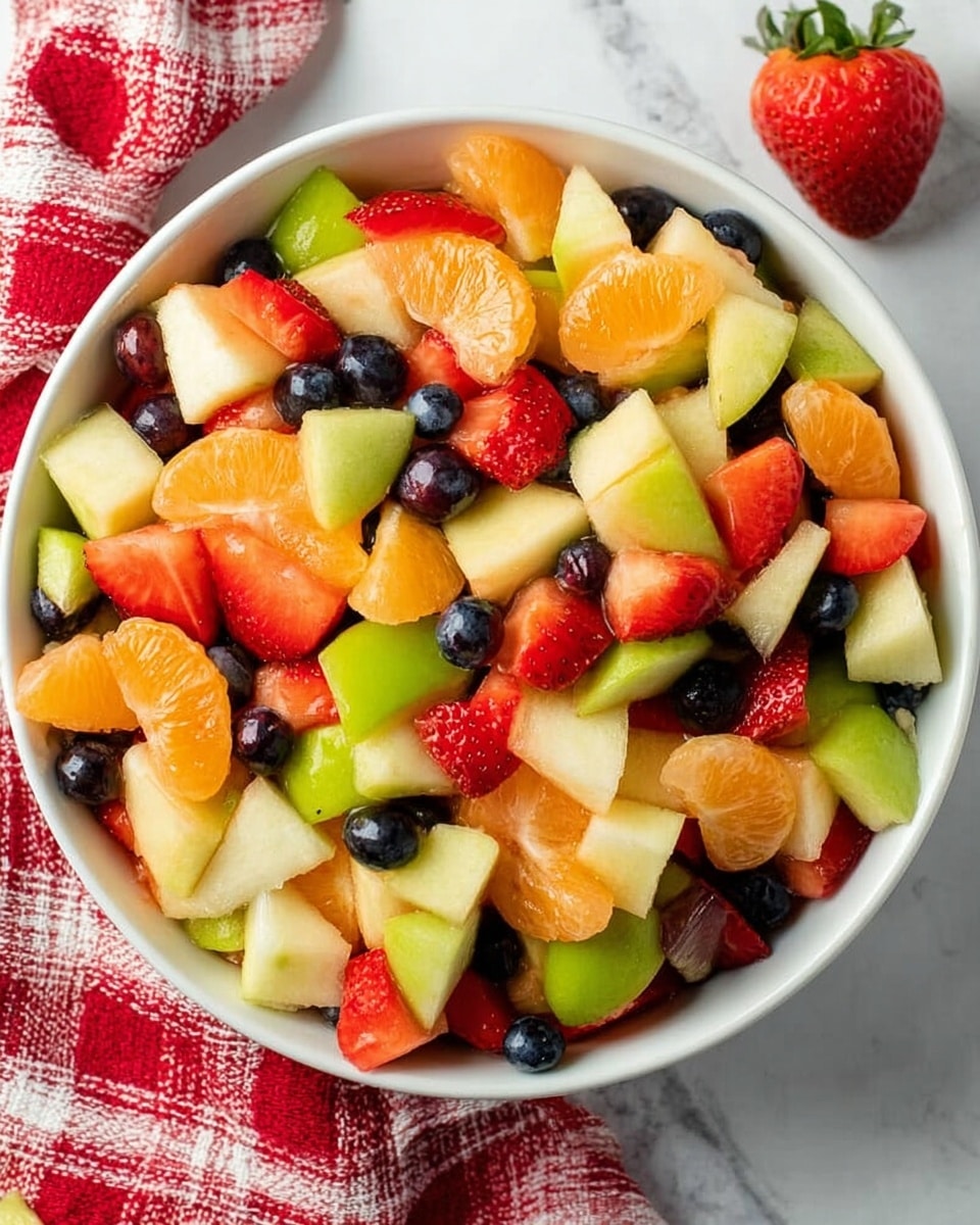 A white bowl filled with a colorful fruit salad sits on a white marbled surface. The fruit salad has many pieces mixed together in one layer, showing chunks of green apple with light green skin, bright orange mandarin slices, deep red strawberry pieces, juicy red apple bits, and small dark blue blueberries. The fruits are fresh and cut into small, bite-sized pieces, creating a mix of vibrant red, orange, green, and blue colors. A red and white checkered cloth is placed near the bowl, adding a cozy touch. Photo taken with an iphone --ar 4:5 --v 7