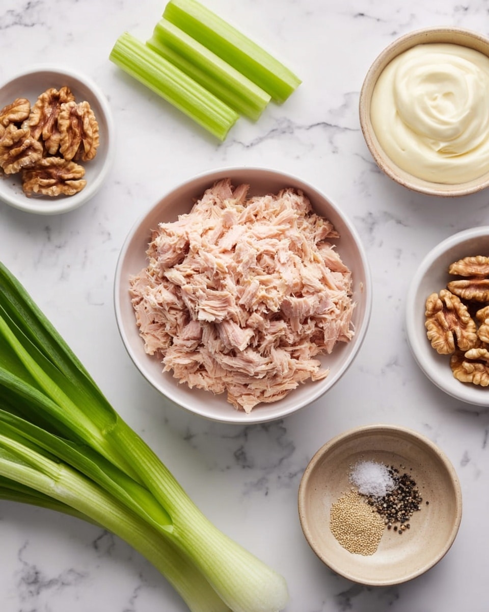 The image shows a white round bowl filled with light pink shredded tuna in the center, surrounded by several small dishes and fresh vegetables on a white marbled surface. To the left, there are three green onions and three celery sticks aligned in a row. At the top right, there is a small white bowl with creamy white mayonnaise, below that a wider white bowl holds walnut halves, and at the bottom right, a beige dish contains a mix of black pepper and white salt. The colors are soft and natural, with a focus on the light pink tuna and fresh green vegetables. Photo taken with an iphone --ar 4:5 --v 7