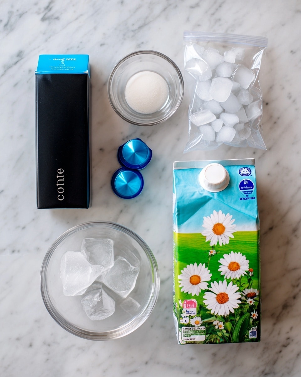The image shows four items on a white marbled surface: a tall, slim black box with blue at the top labeled coffee, two small blue coffee pods, a small clear glass bowl filled with white sweetener powder, and a clear plastic zipper bag filled with ice cubes. On the right side, a colorful 2-liter milk carton with green fields and a white daisy illustration is visible. Each item is neatly spaced and clearly labeled with bold pink text on white rectangles reading