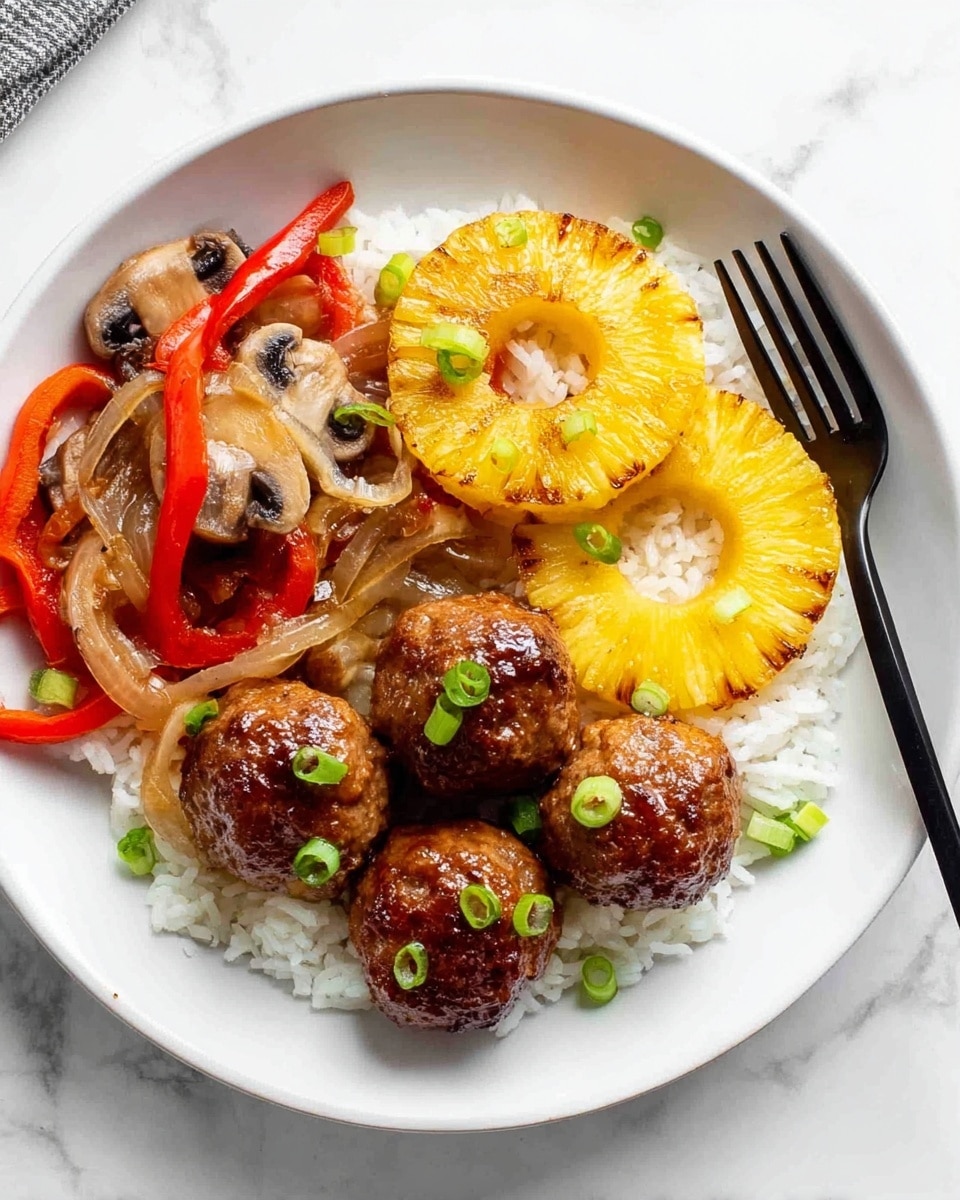 A white plate holds a dish with four shiny brown meatballs placed on the right side over a bed of white rice. Above the meatballs are two golden brown grilled pineapple rings garnished with small green onion slices. On the left side, there are sautéed vegetables including red bell pepper strips, caramelized onion slices, and mushrooms with a slightly browned texture. A black fork rests on the right edge of the plate. The plate sits on a white marbled surface. photo taken with an iphone --ar 4:5 --v 7