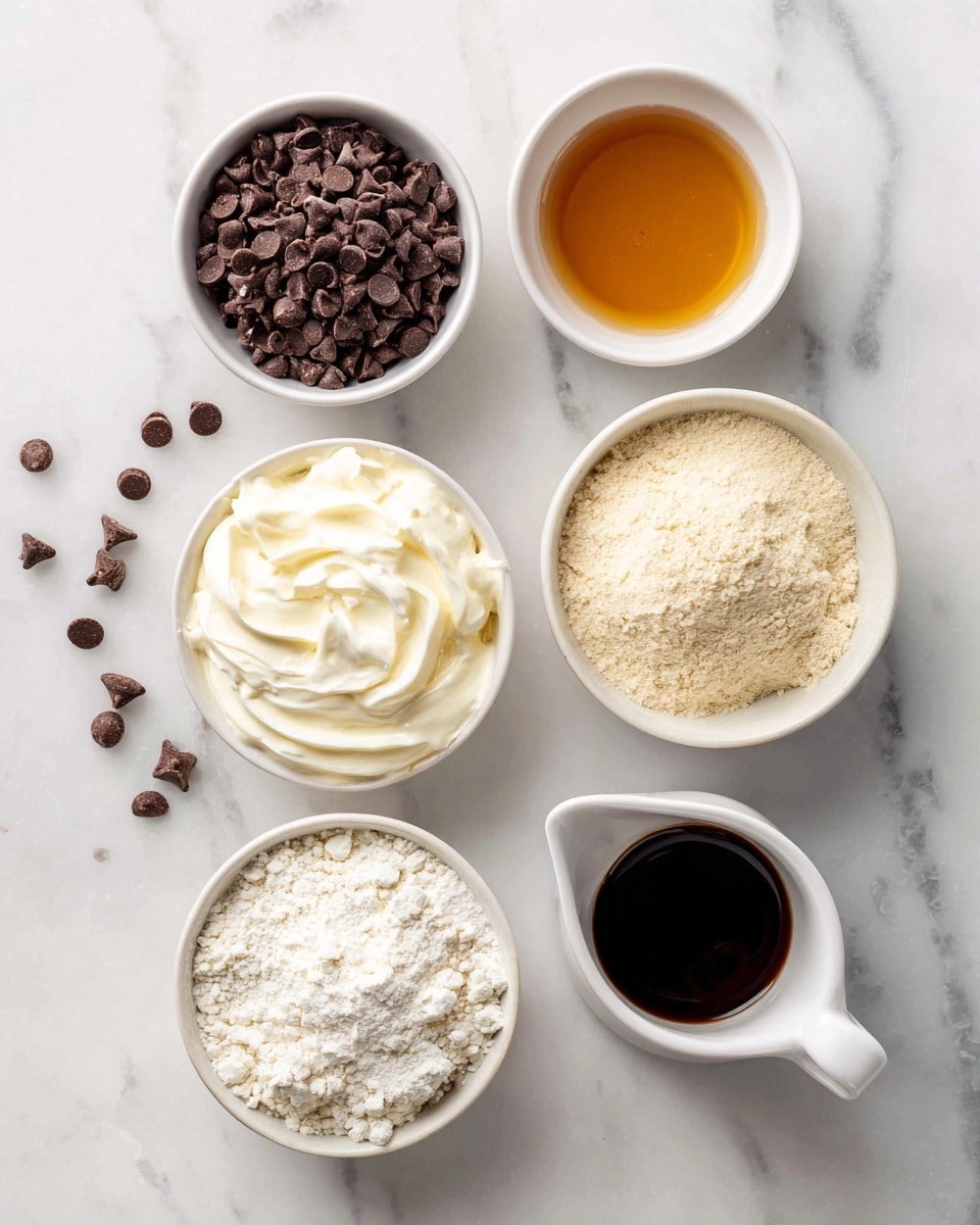 The image shows six white bowls with different ingredients placed on a white marbled surface. From top left to bottom right, there is a bowl filled with small dark brown chocolate chips, a small bowl of amber-colored vanilla liquid, a bowl with pale yellow vanilla whey protein powder, a bowl of thick white Greek yogurt with soft swirls, a small white jug filled with dark amber maple syrup, and a bowl containing light beige almond flour with a fine, powdery texture. The bowls are arranged neatly apart from each other, with a few chocolate chips scattered on the surface near the top left bowl photo taken with an iphone --ar 4:5 --v 7